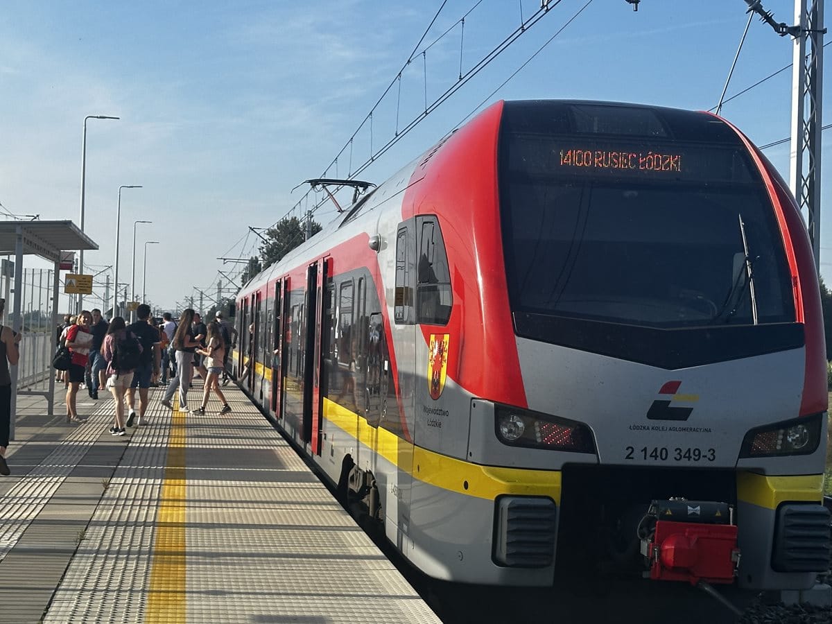 Pociąg Łódzkiej Koleji Aglomeracyjnej (ŁKA) stojący na peronie stacji Rusiec Łódzki, obok pociągu stoi grupa osób